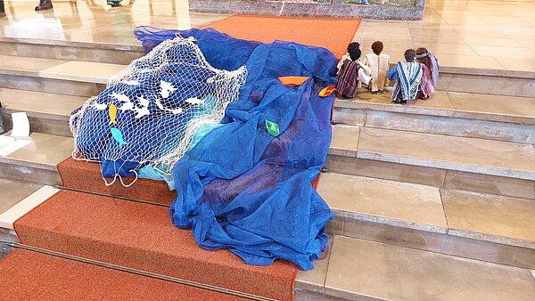 Gottesdienst der Kommunionkinder - drapierter See und Fischer auf den Stufen zum Altar